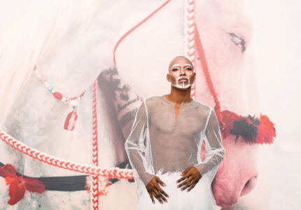 model J Daniel Barlow wearing an Elaine Healey creation in front of a mimi Cherono Ng'ok photograph